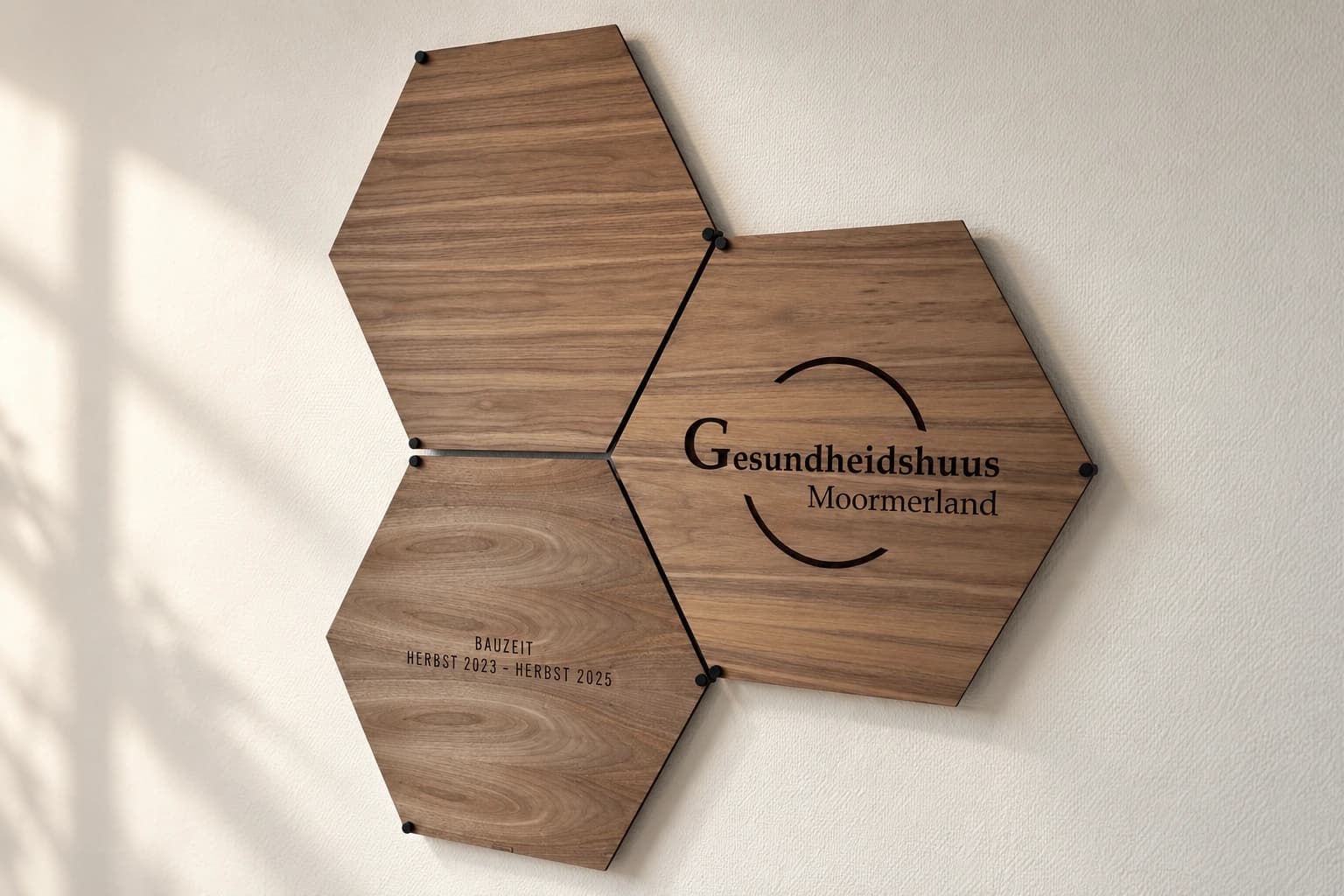 Dreiteilige Holz-Wandinstallation mit Logo und Bauzeit des Gesundheidshuus Moormerland